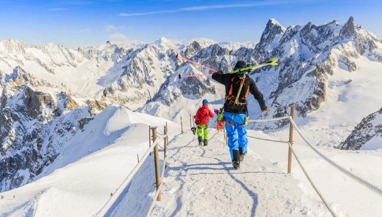 Narty w luksusowym wydaniu, kurort narciarski w górach, ludzie z nartami