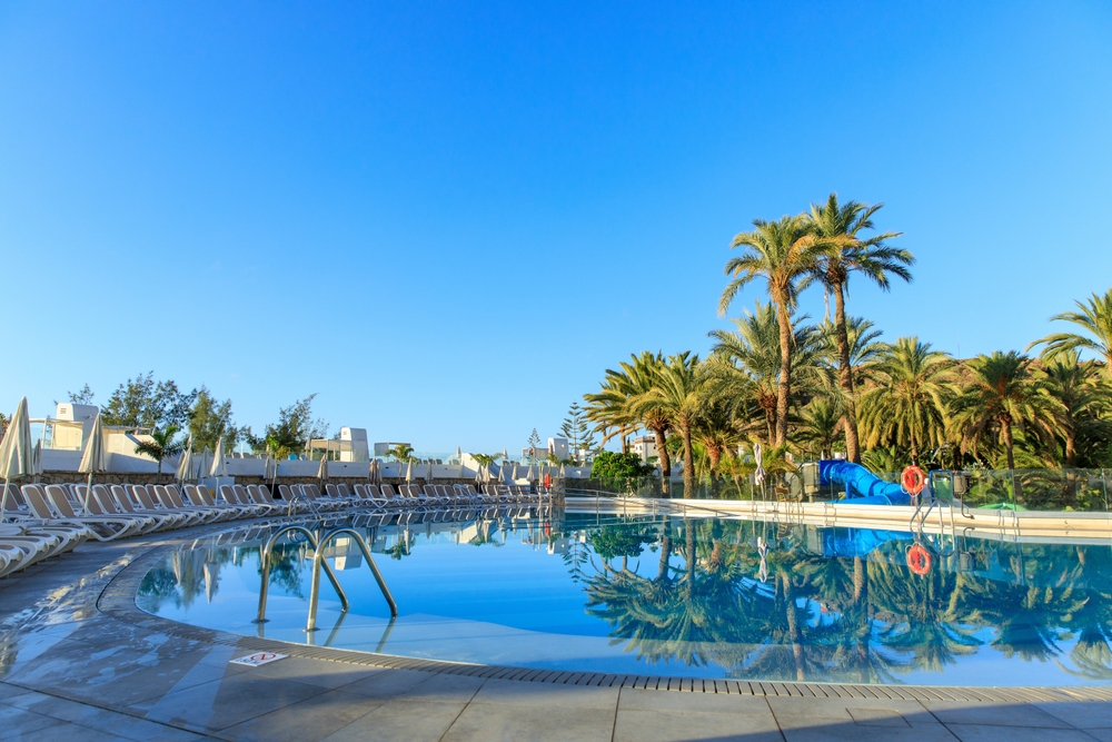 Basen w hotelu All Inclusive z palmami w tle.